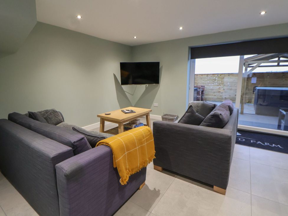A living room with a sofa and tv at Willow Barn in Saughall