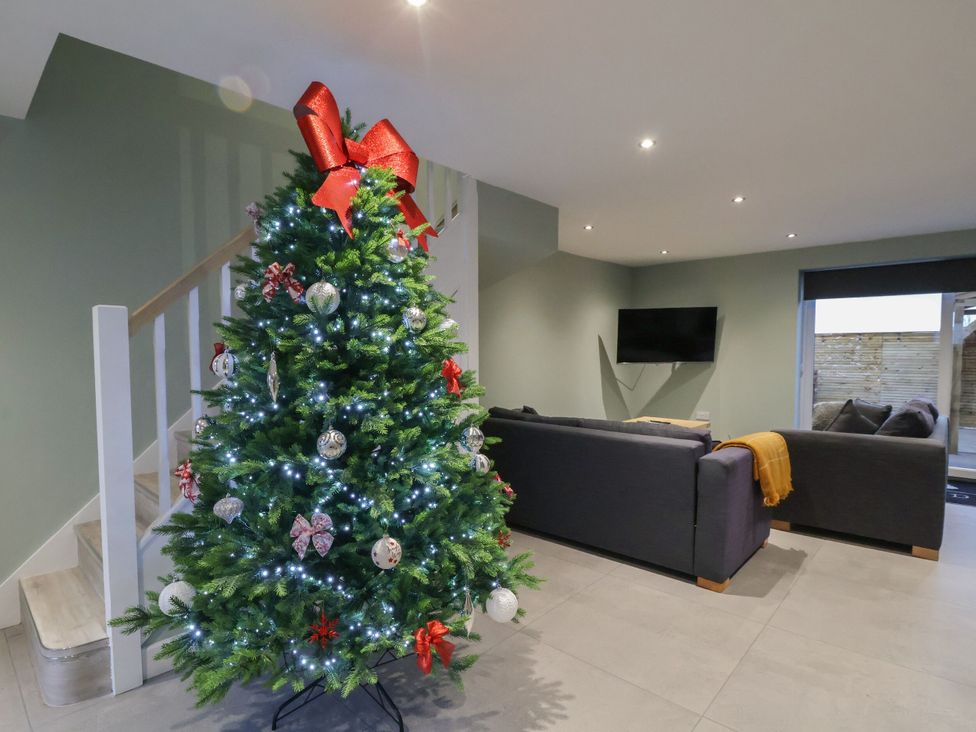 A living room with a Christmas tree and a sofa at Willow Barn in Saughall