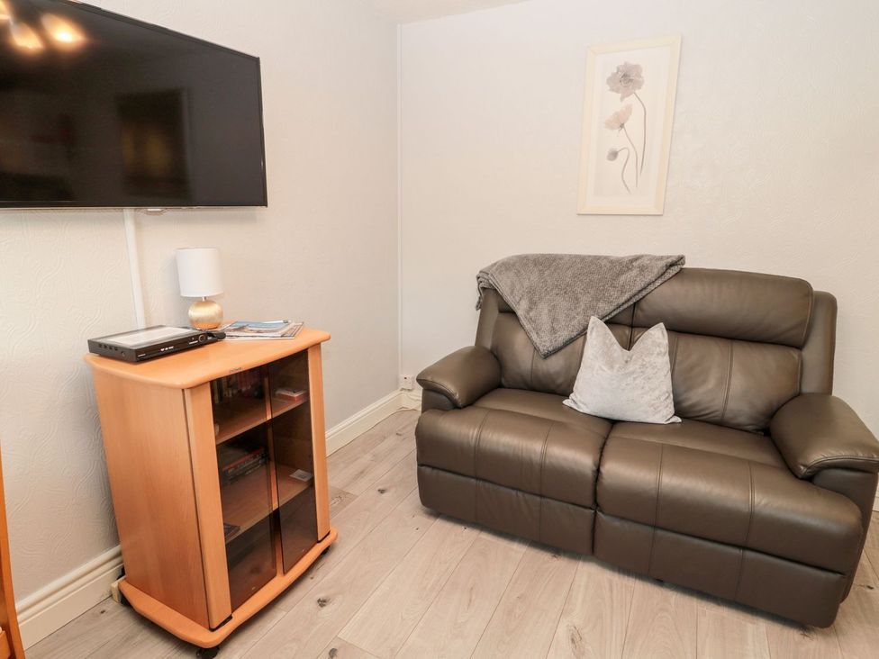 A living room with a sofa and television at Primrose Cottage in Chathill