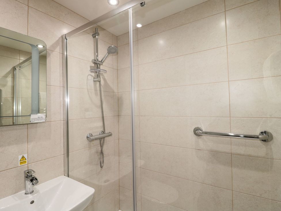 A shower and sink in a bathroom at Primrose Cottage in Chathill