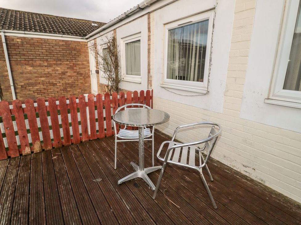 An outdoor seating area with a table and chairs at Primrose Cottage in Chathill