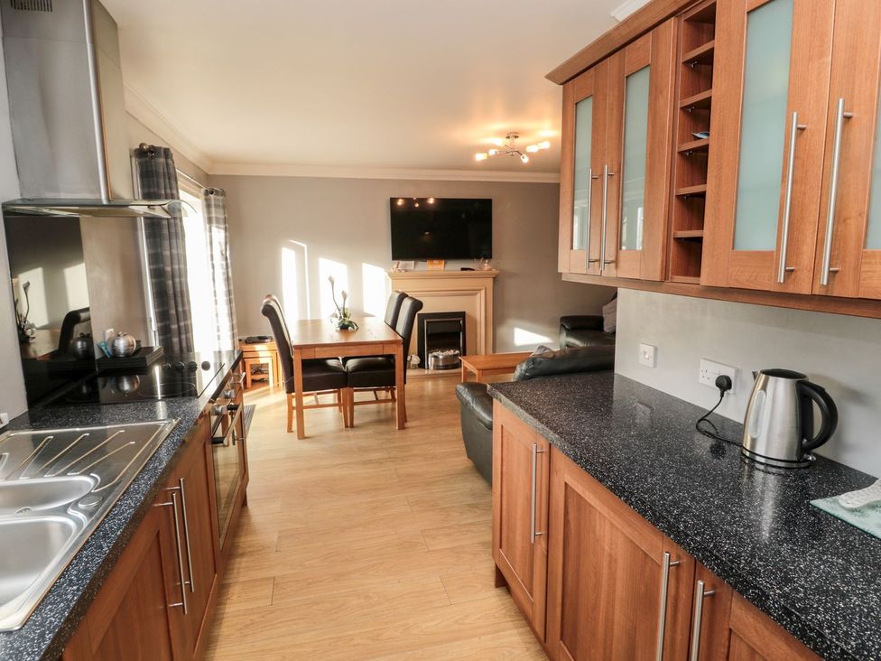 A kitchen with a dining table and television at Megstone in Chathill