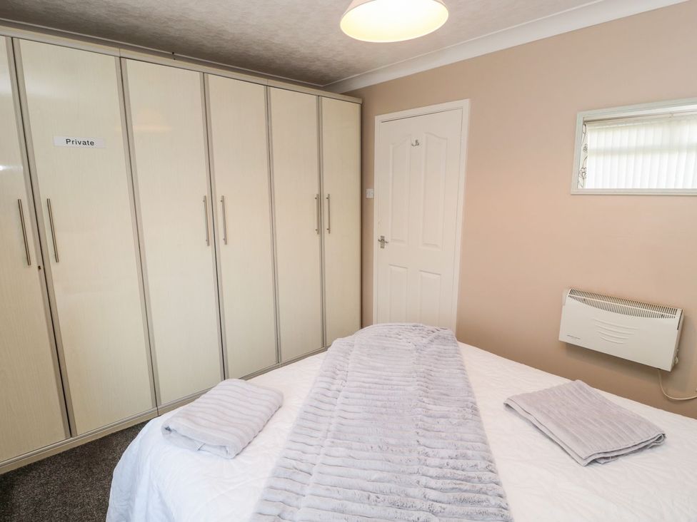 A bedroom with a bed and wardrobe at Megstone in Chathill