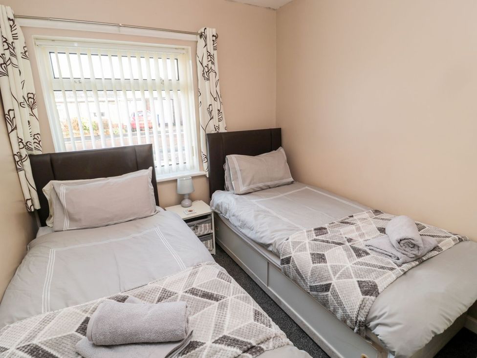 A bedroom with two single beds and a window at Megstone in Chathill