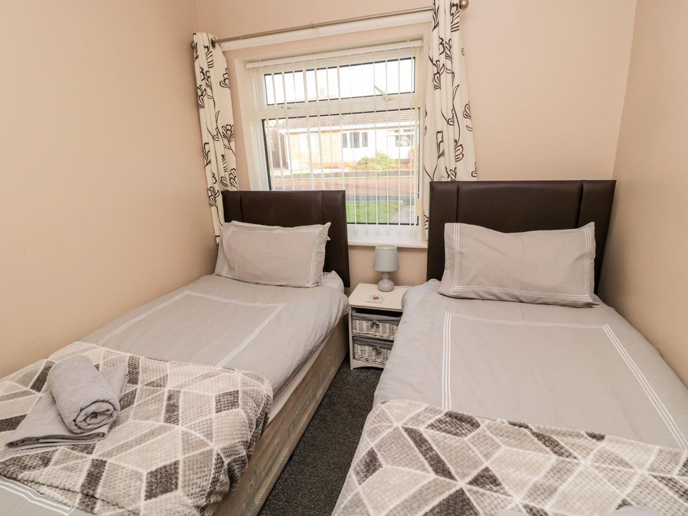 A bedroom with two single beds and a window at Megstone in Chathill