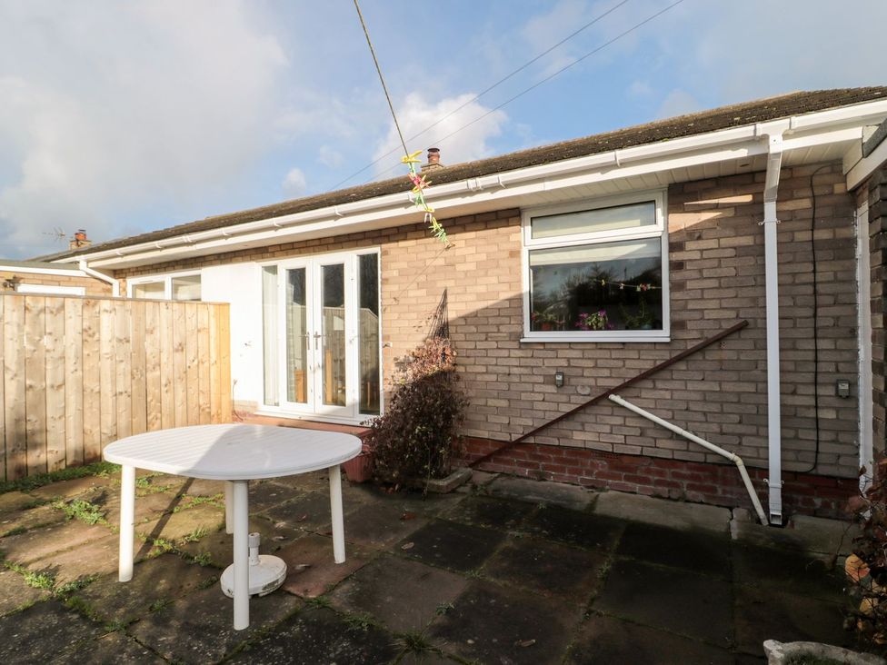 A garden with a table and fence at Megstone in Chathill