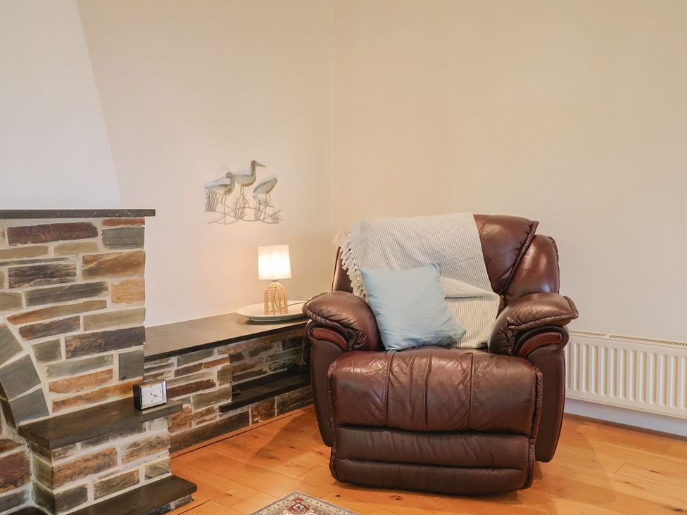 A living room with an armchair and a lamp at Hawksdown Lyme Regis