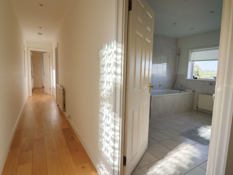 A bathroom with a bathtub visible from the hallway at Hawksdown in Lyme Regis