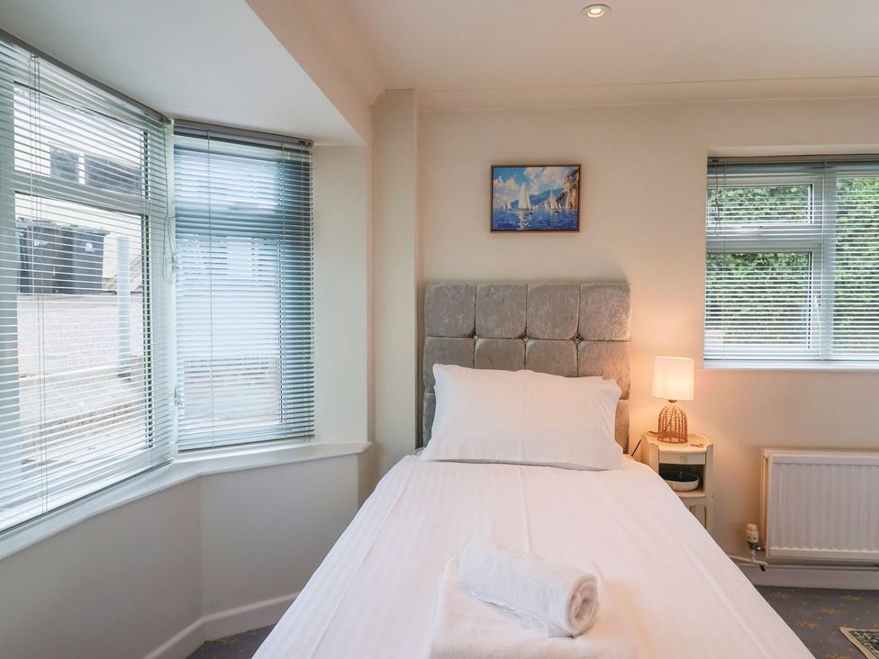 A bedroom featuring a bed with a pillow and towel at Hawksdown in Lyme Regis