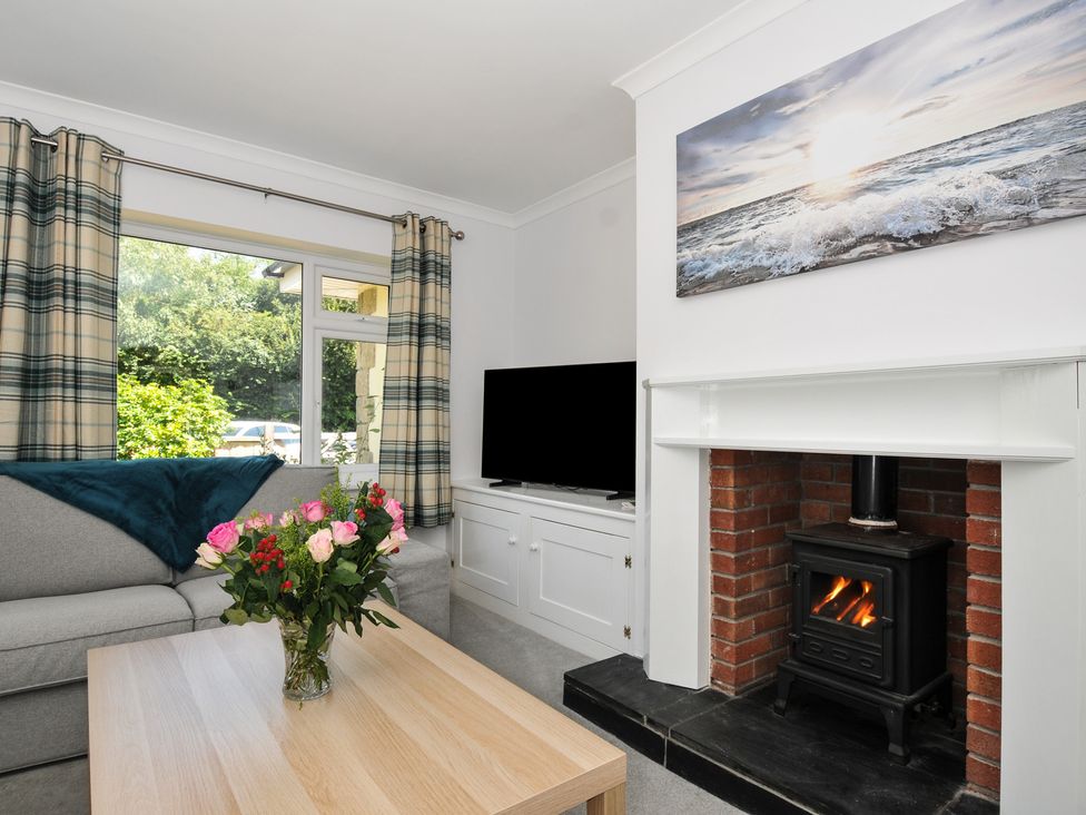 A living room with a coffee table and fireplace at Jazmine in Dacre