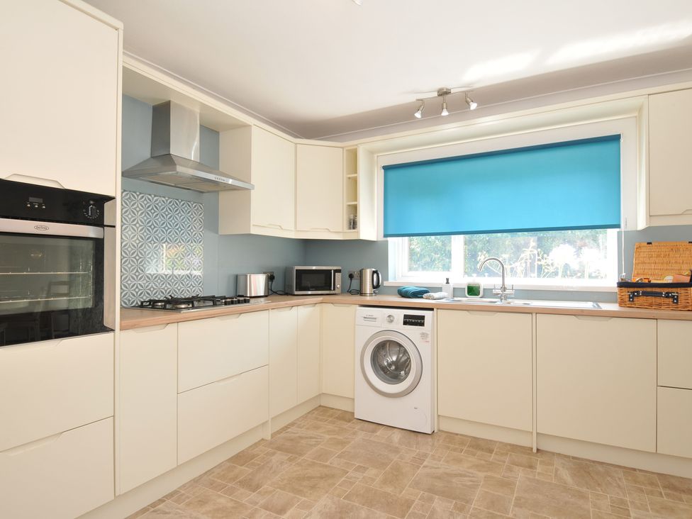 A kitchen with appliances and a window at Jazmine in Dacre