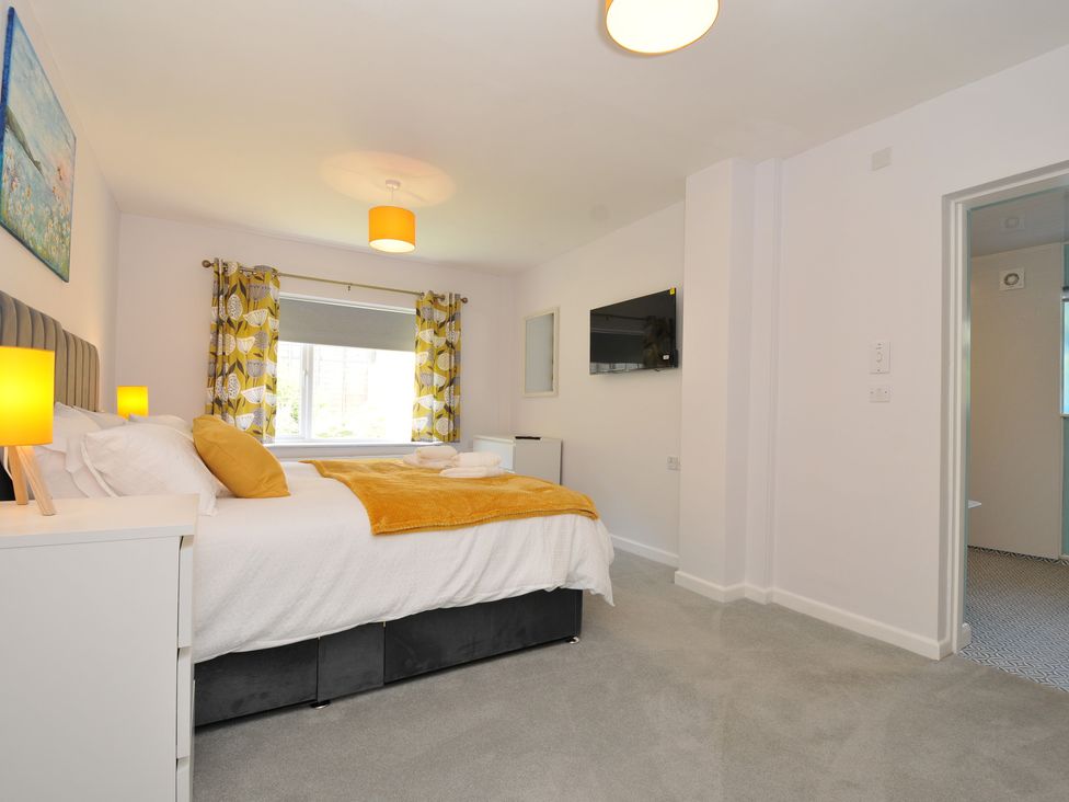 A bedroom with a bed and nightstand at Jazmine in Dacre