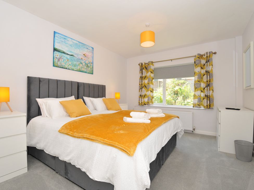A bedroom with a bed and artwork at Jazmine in Dacre