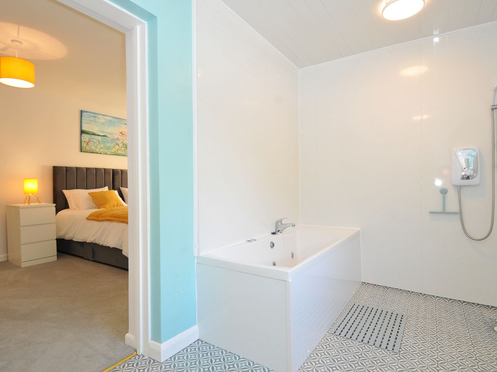 A bathroom with a bathtub and shower at Jazmine in Dacre