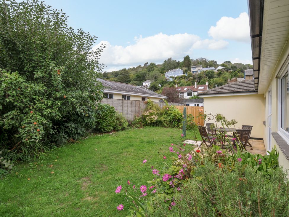 An outdoor garden with grass and furniture at Jazmine in Seaton