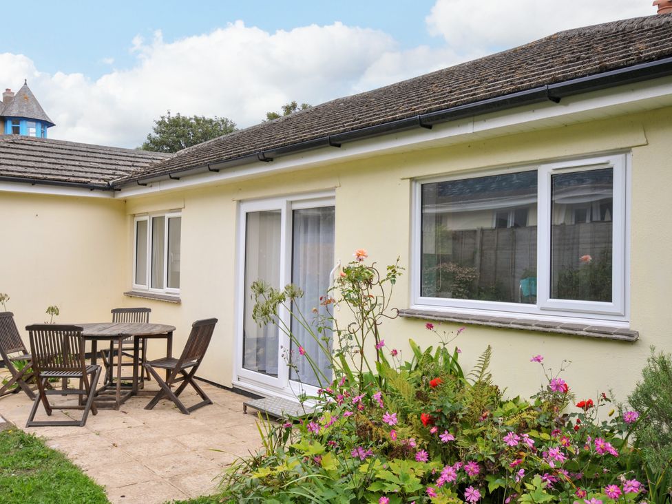 A garden with a table and chairs at Jazmine in Seaton