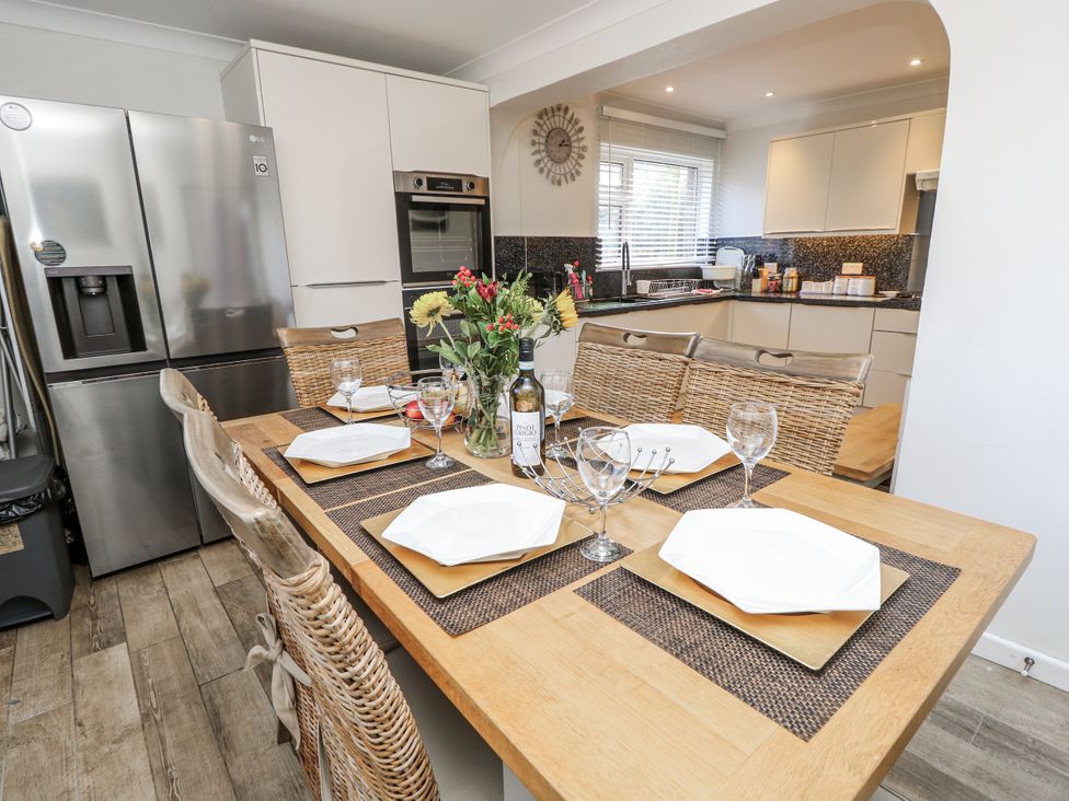 A kitchen with a dining table set and appliances at Red Brick Haven in East Cowes, Isle Of Wight