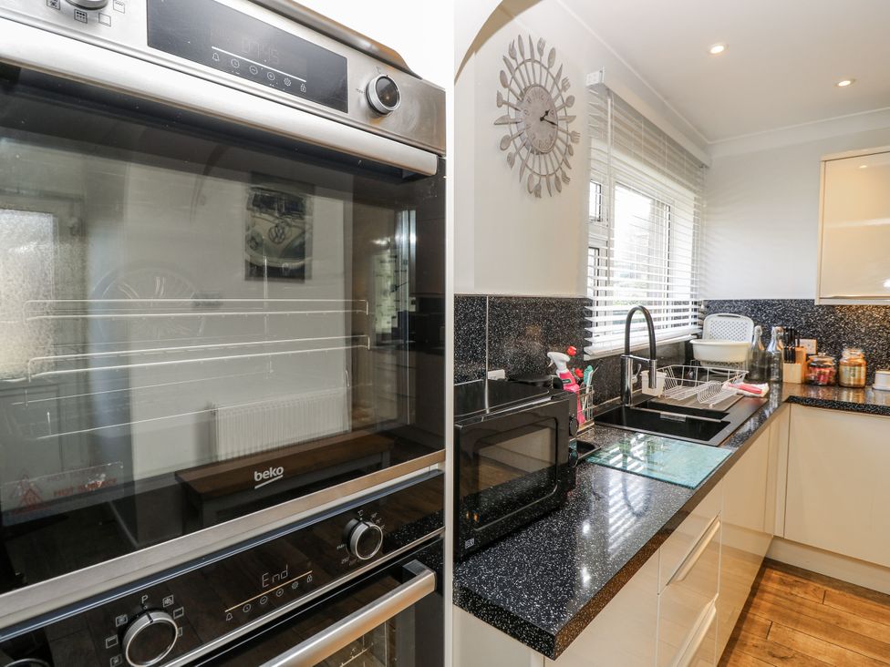 A kitchen with an oven, microwave, and sink at Red Brick Haven in East Cowes, Isle Of Wight