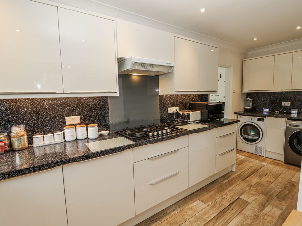 A kitchen with cabinets, kitchen counter, stove and washing machine at Red Brick Haven East Cowes, Isle Of Wight