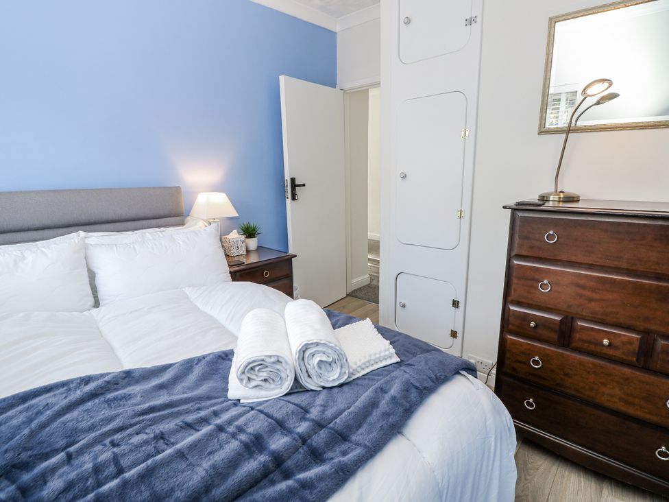A bedroom with a bed and bedside lamp at Red Brick Haven, East Cowes, Isle Of Wight
