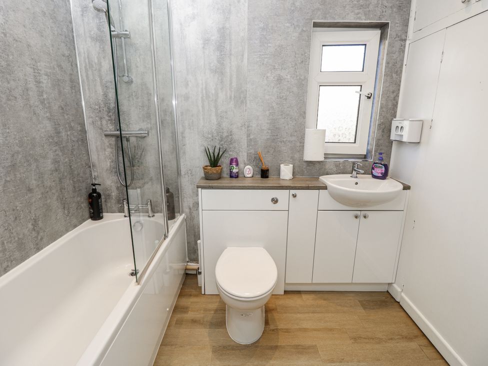 A bathroom featuring a bathtub, toilet, sink, and cabinet at Red Brick Haven in East Cowes, Isle Of Wight