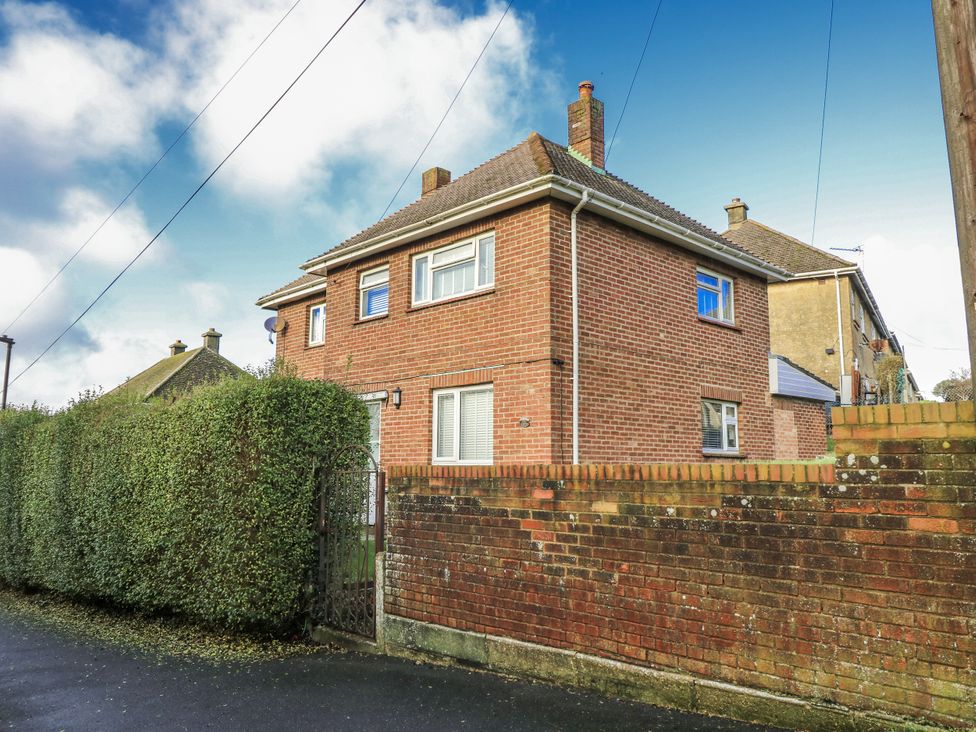 A house with a brick wall and hedge at Red Brick Haven, East Cowes, Isle Of Wight