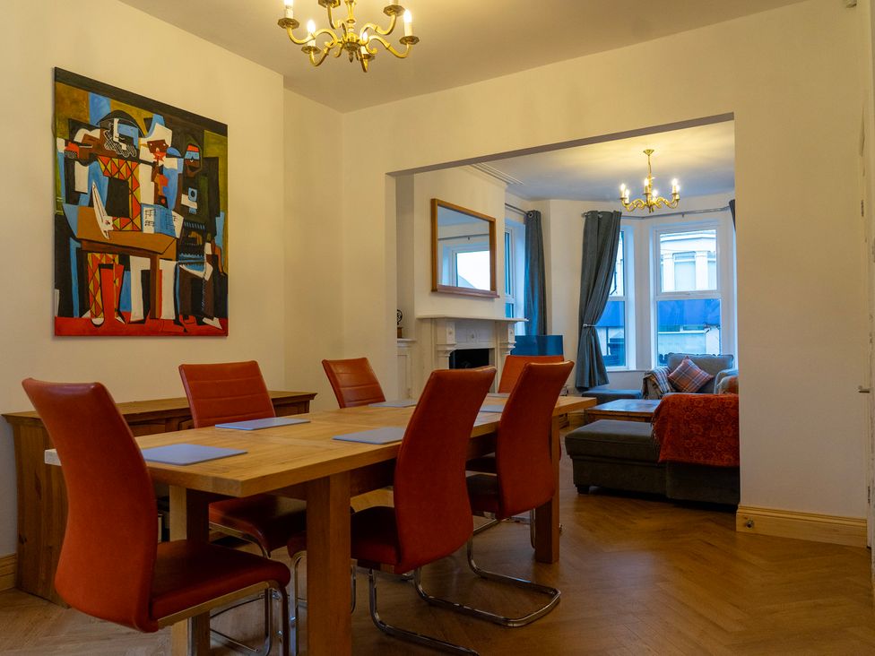 A dining room with a table and chairs and a painting at The Red Door 