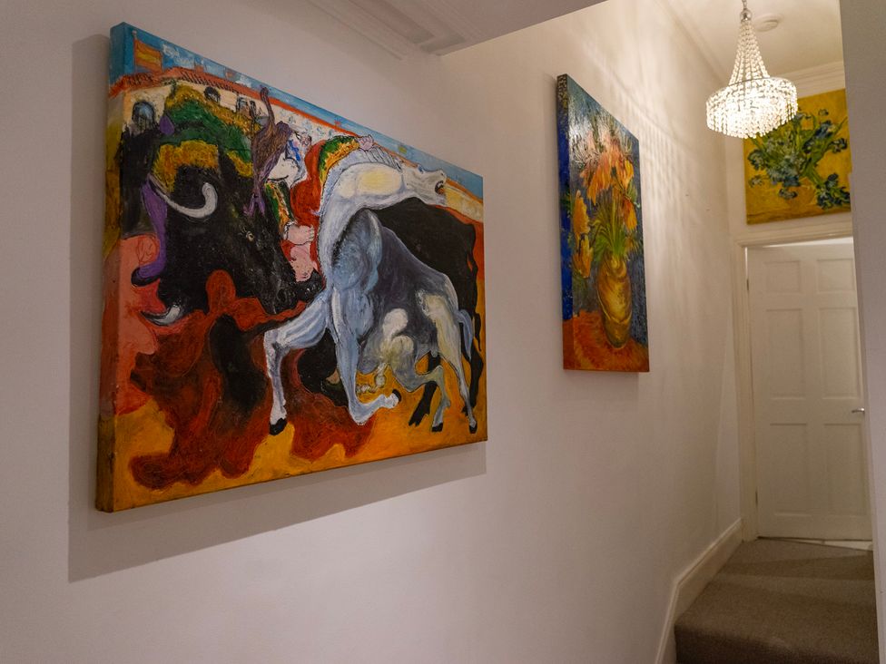 A hallway with paintings on the wall at The Red Door in 