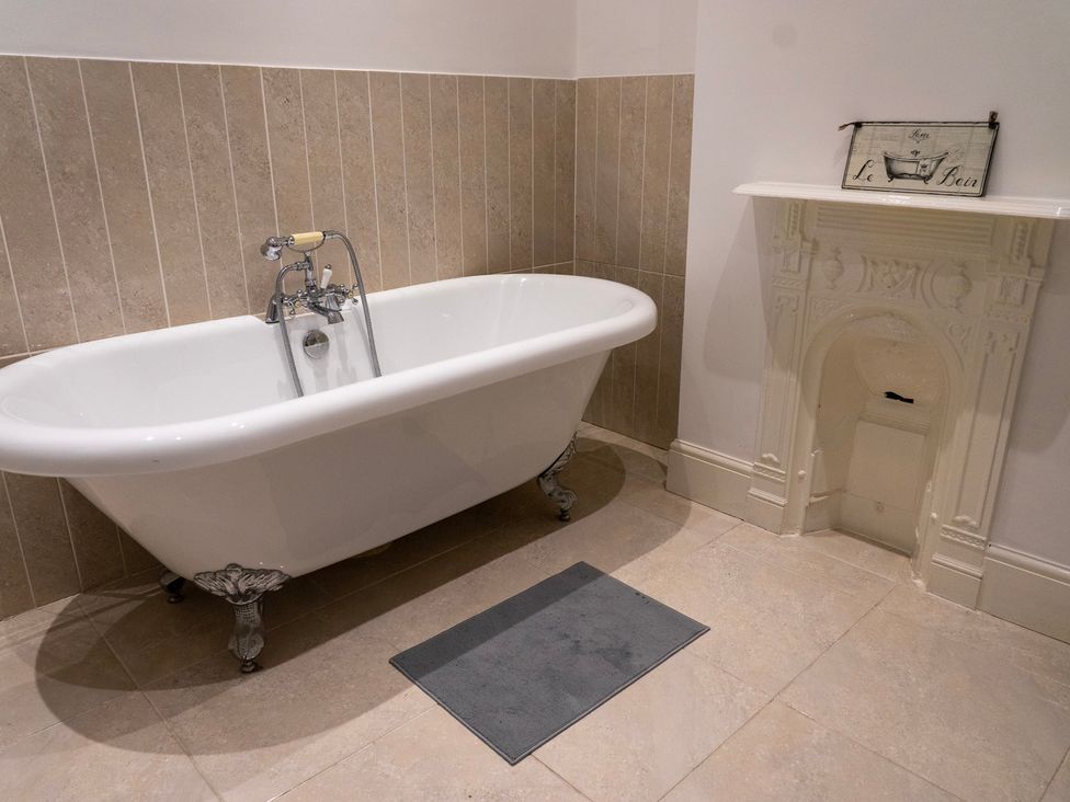 A bathroom featuring a bathtub and a fireplace at The Red Door 