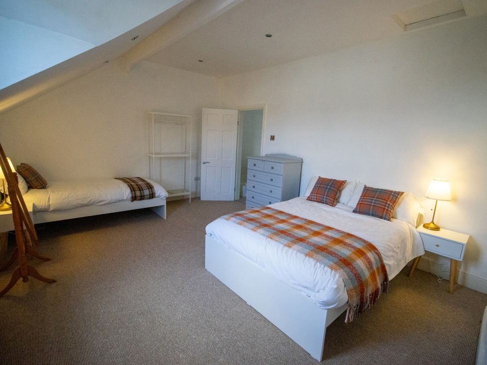 A bedroom with two beds and storage furniture at The Red Door in Bangor