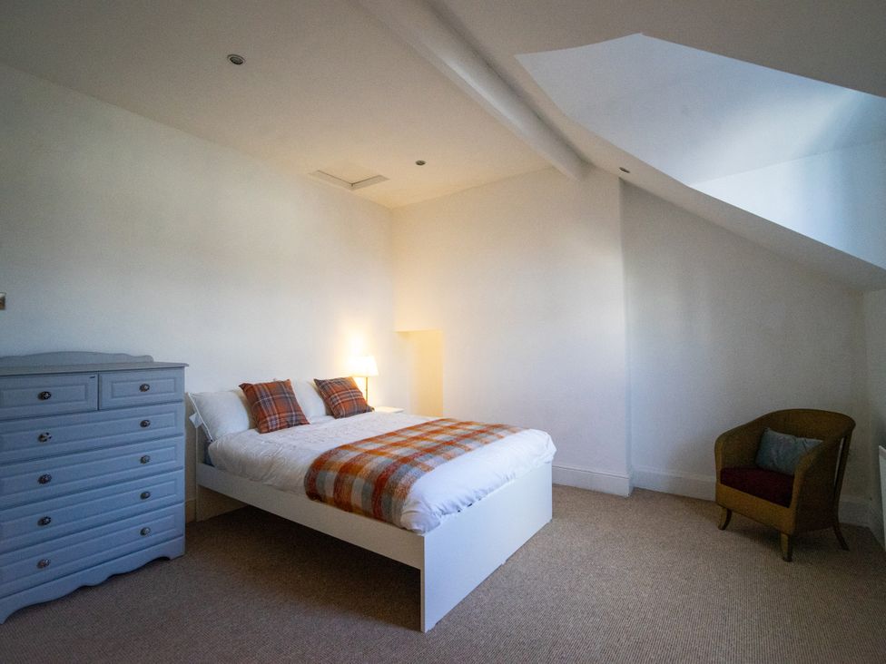 A bedroom with a bed and dresser at The Red Door in Bangor