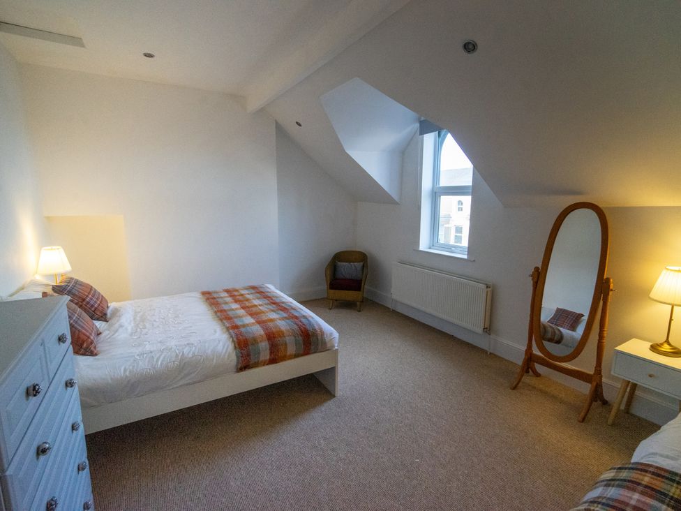 A bedroom with a bed and a chair at The Red Door in Bangor