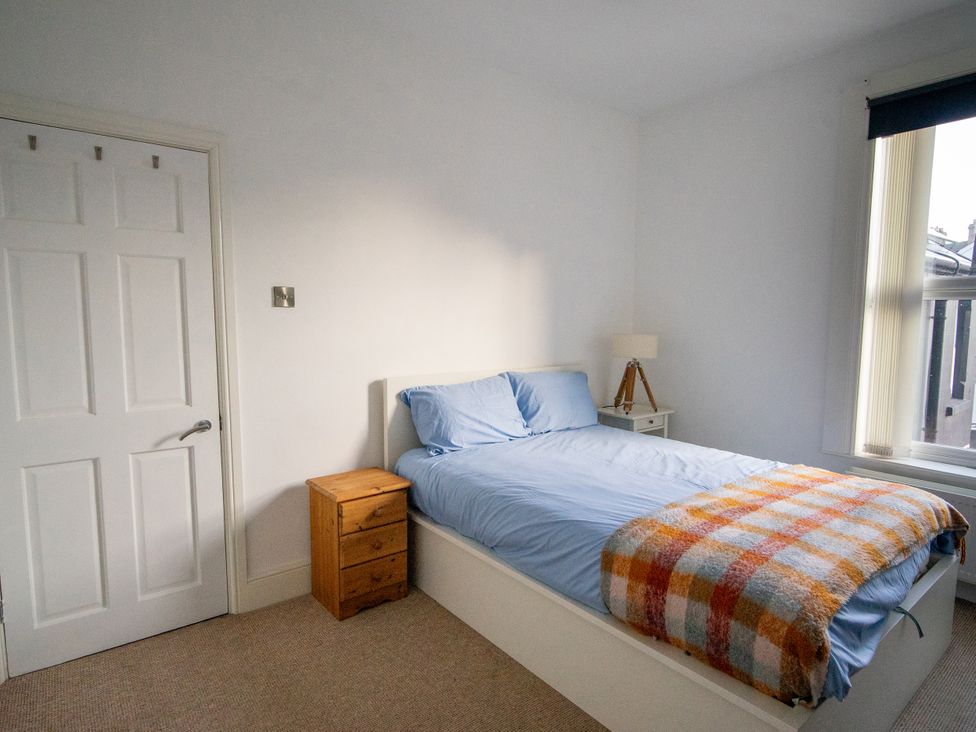 A bedroom with a bed, nightstand, and lamp at The Red Door in Bangor