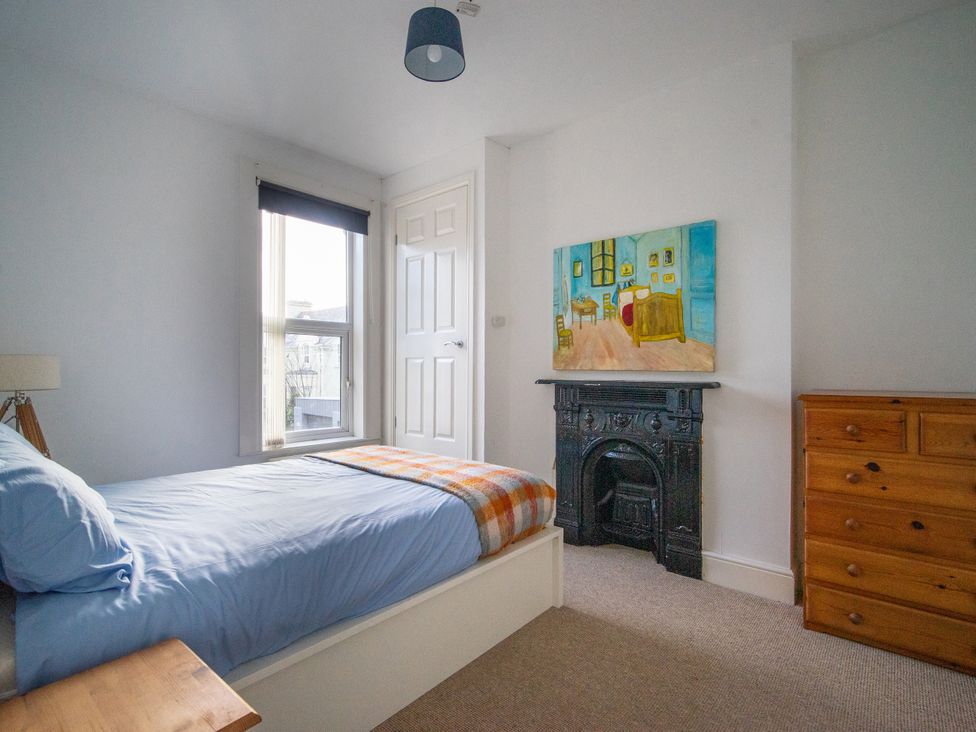 A bedroom with a bed and painting at The Red Door in Bangor