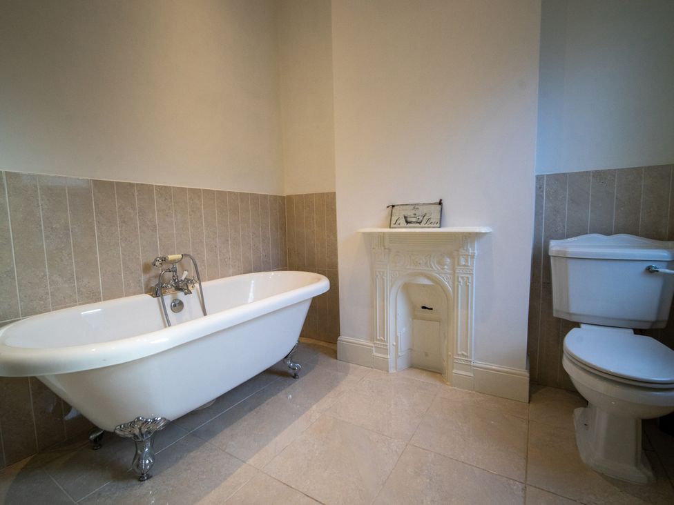 A bathroom with a bathtub and toilet at The Red Door in Bangor