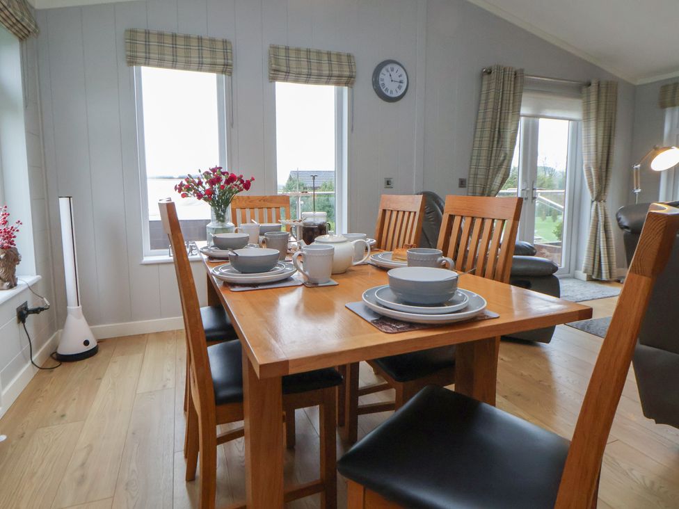 A dining room with a table set for breakfast at Holly Lodge in Lloc near Caerwys