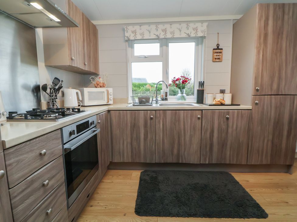 A kitchen with a sink and appliances at Holly Lodge in Lloc near Caerwys