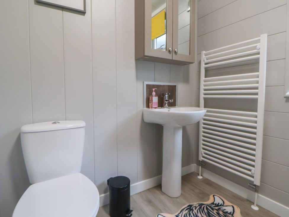 A bathroom with a toilet and sink at Holly Lodge in Lloc near Caerwys