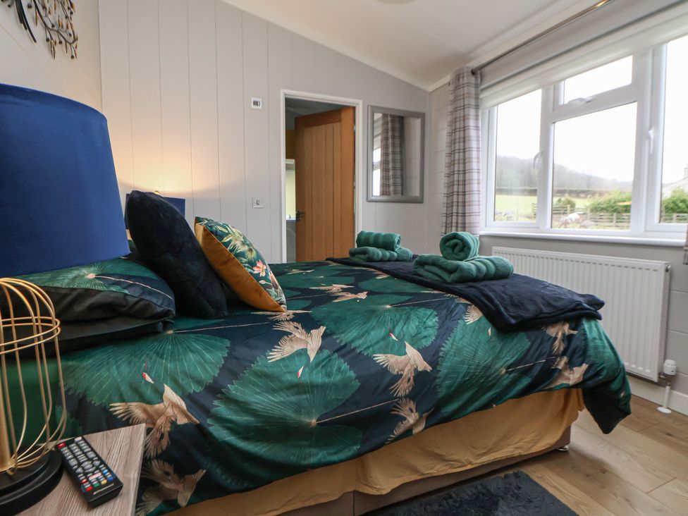 A bedroom with a bed and pillows at Holly Lodge in Lloc near Caerwys