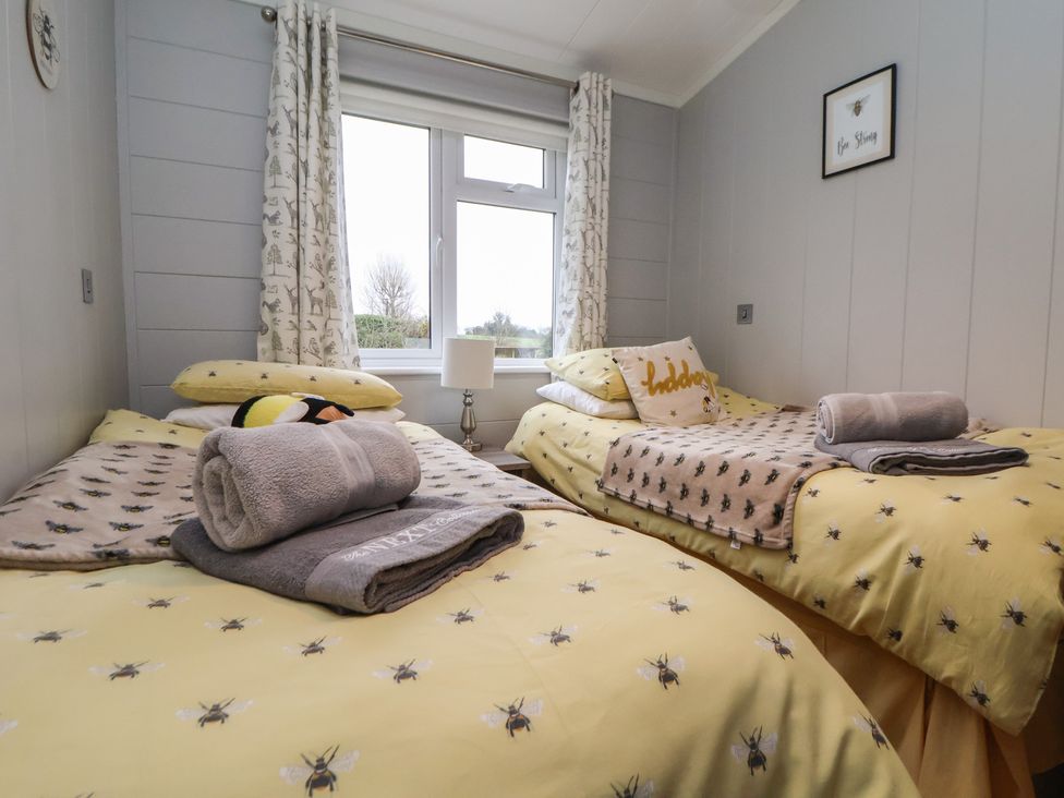 A bedroom with two beds and a window at Holly Lodge in Lloc near Caerwys