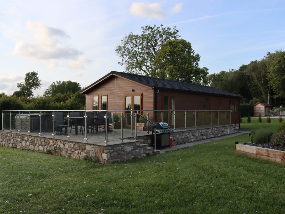 A lodge with a balcony and garden at Pine Lodge in Lloc near Caerwys