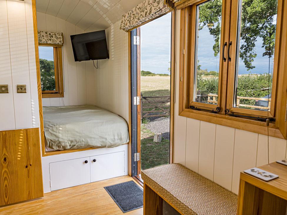 A bedroom with a bed and television at No 2 The Parkland in Upton Warren