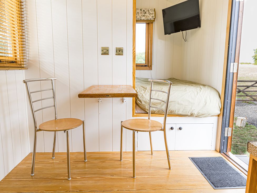 A sitting room with chairs and a table at No 2 The Parkland in Upton Warren