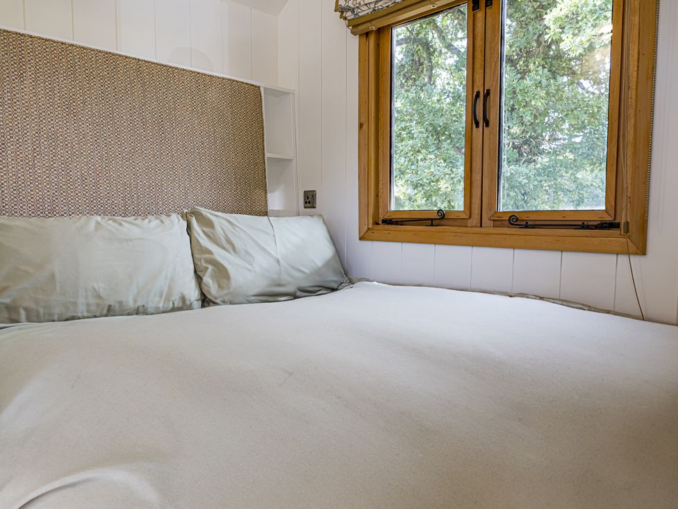 A bedroom with a bed and window at No 2 The Parkland in Upton Warren