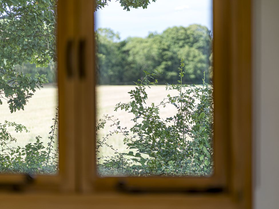 A view through a window showing trees and a field at No 2 The Parkland Upton Warren