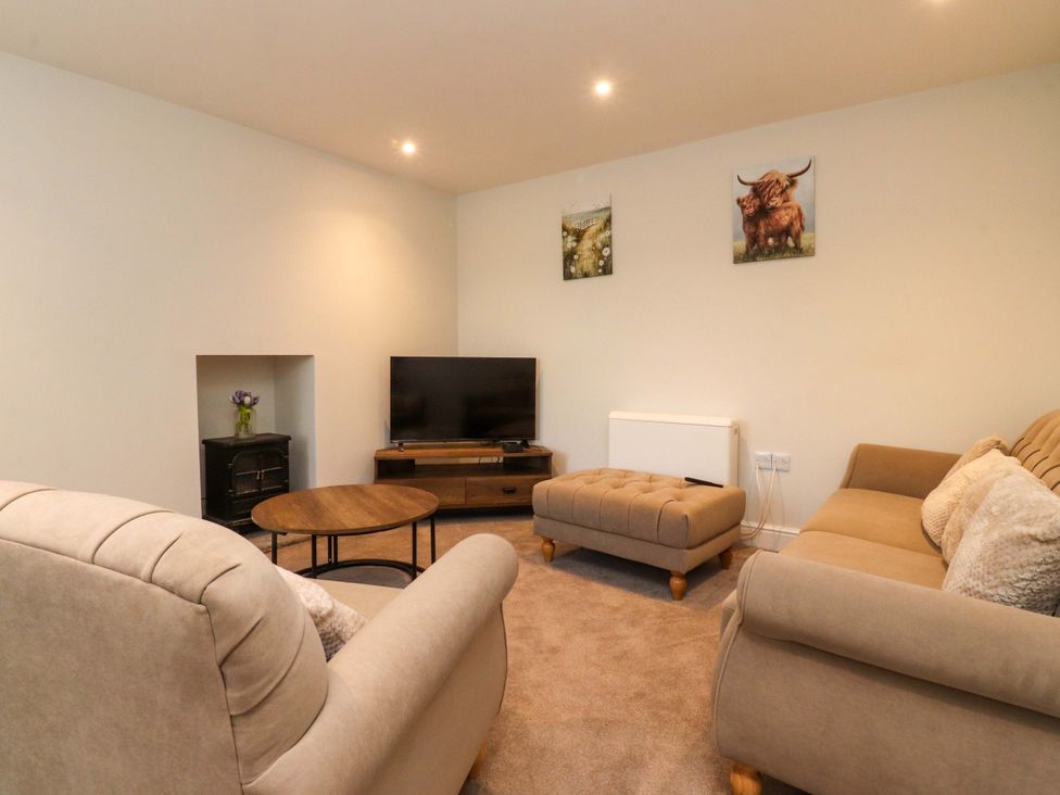A living room with a television and seating area at Cowside Farm in Langcliffe near Settle