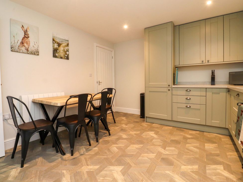 A kitchen with a table and chairs at Cowside Farm in Langcliffe near Settle