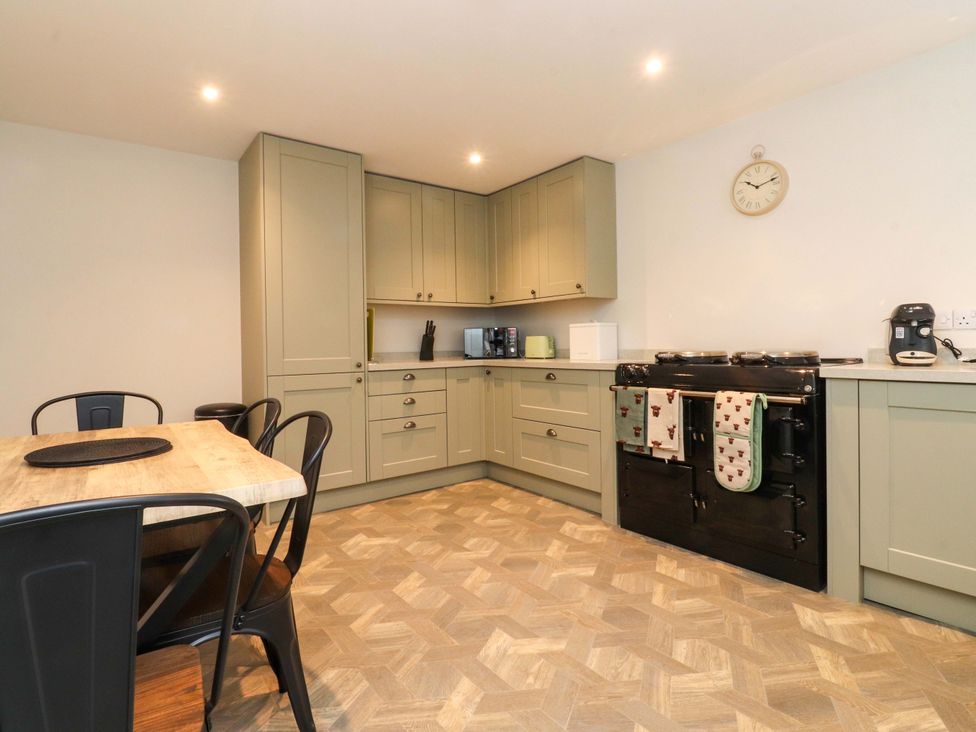 A kitchen with cabinets and a dining table at Cowside Farm in Langcliffe near Settle