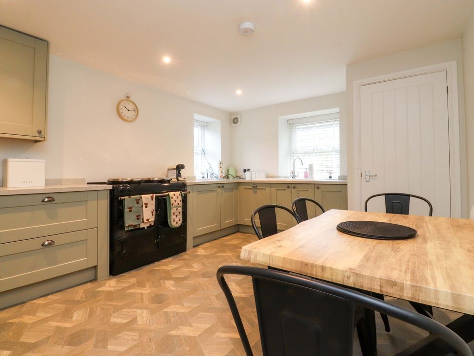 A kitchen with a table and chairs at Cowside Farm in Langcliffe near Settle