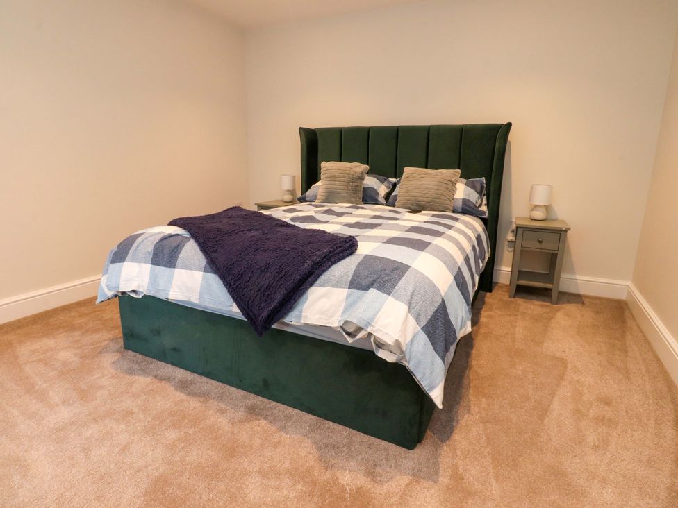 A bedroom with a green bed and bedside table at Cowside Farm in Langcliffe near Settle